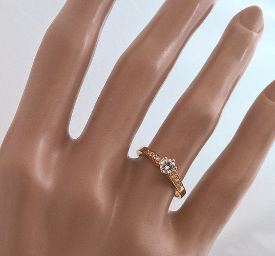 Solitaire ring with accompanying diamonds in 18k yellow gold
